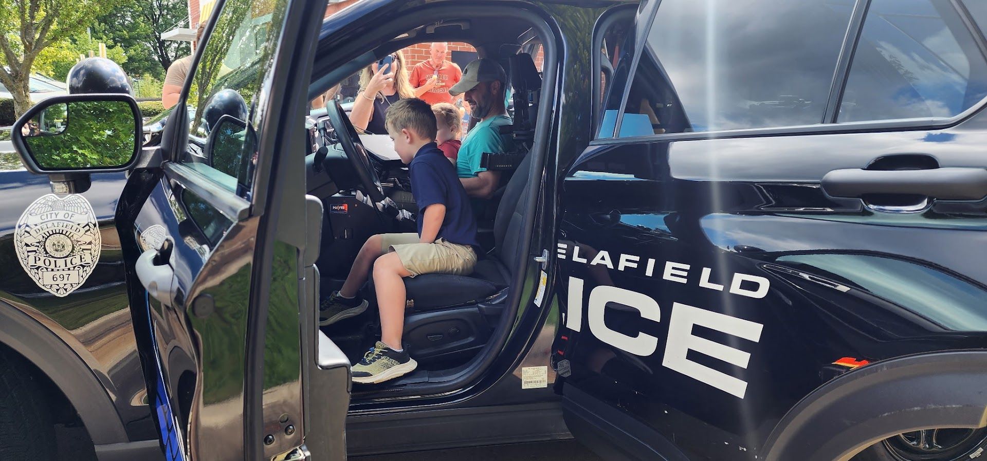 A kid tries the driver's seat of a Delafield police SUV