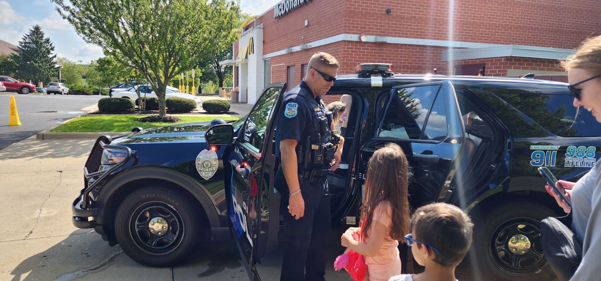 An officer shows the squad car to kids