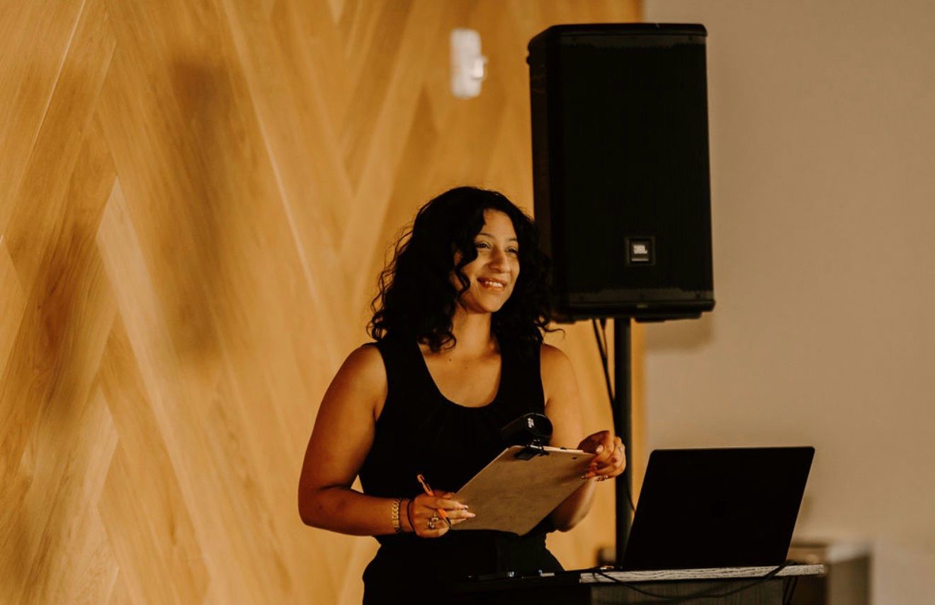 A summit host smiling with her clipboard