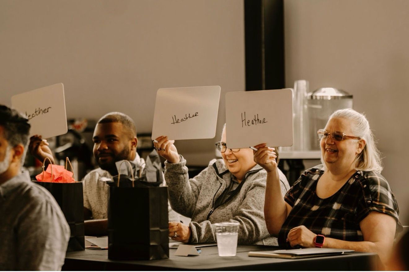 Team tables raising their signs at the Day One summit