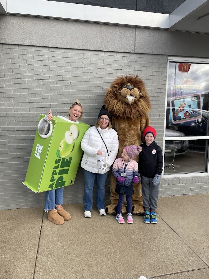 The school lion mascot with families