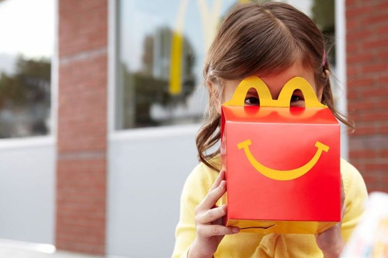 A young guest peeking over a Happy Meal box
